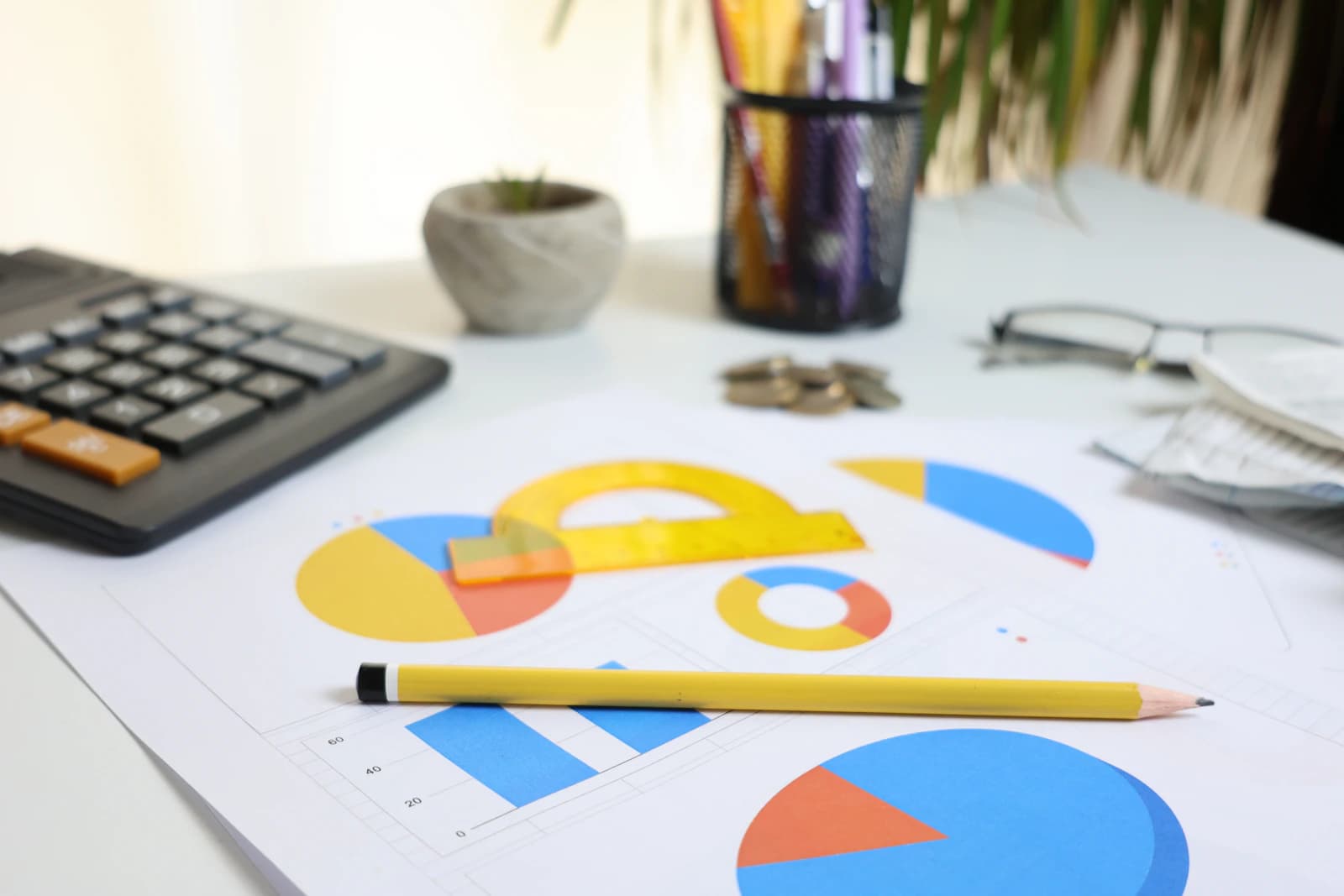 Calculator, pencil and printed charts on a desk, representing website budget planning