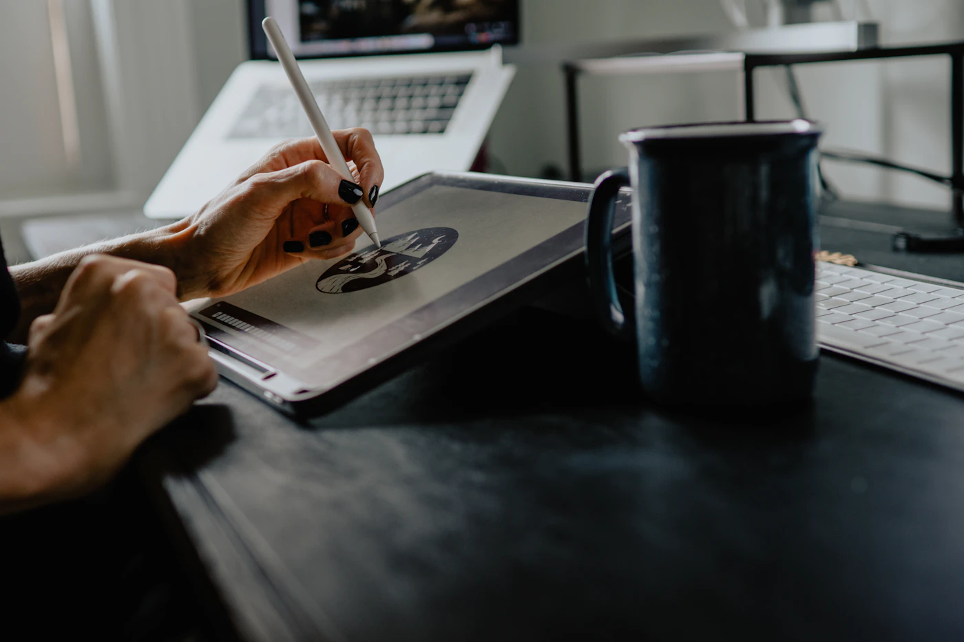 Designer sketching an illustration on a tablet with a stylus at a desk
