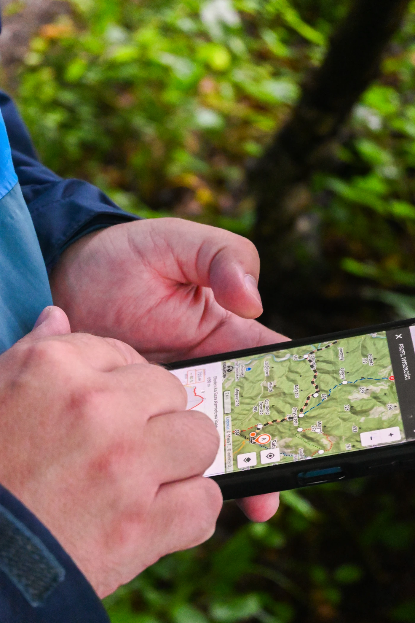 Hands holding a smartphone displaying a map outdoors